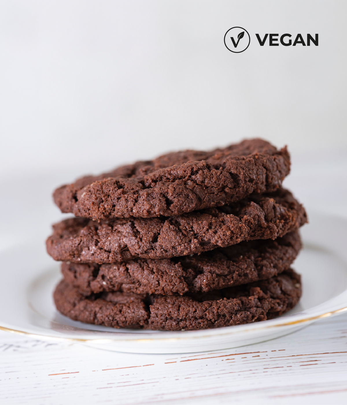 Teller mit vier veganen Schokocookies mit veganem Icon